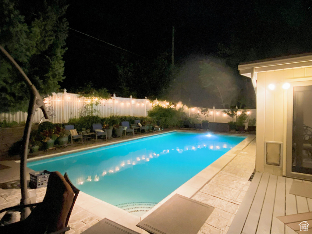 Pool at twilight featuring a fenced backyard