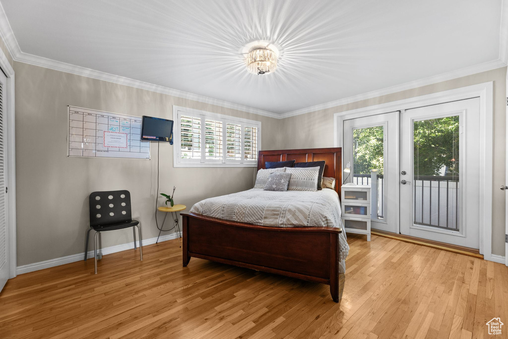Bedroom featuring access to exterior, light wood-style flooring, and ornamental molding