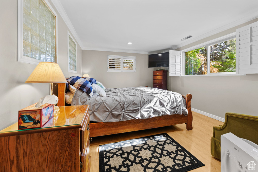 Bedroom featuring crown molding, wood finished floors, and recessed lighting