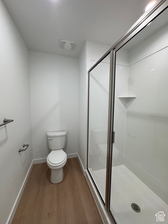 Full bathroom with wood finished floors and a stall shower