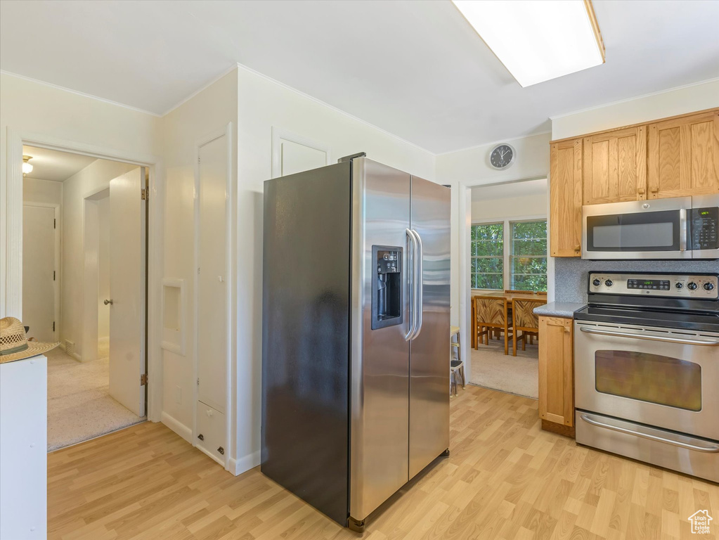 Kitchen featuring appliances with stainless steel finishes and light wood-style floors