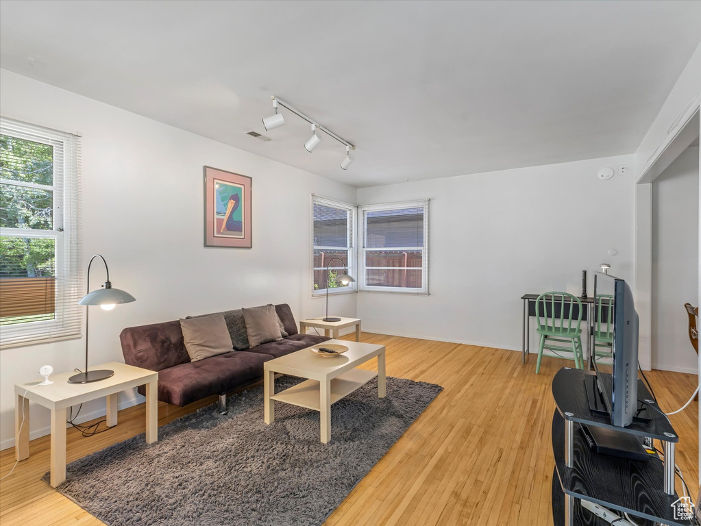 Living room with track lighting and light wood-style floors