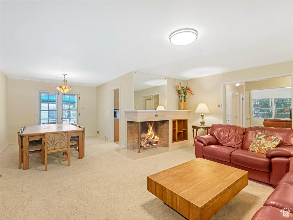 Living area with light colored carpet and a fireplace with flush hearth