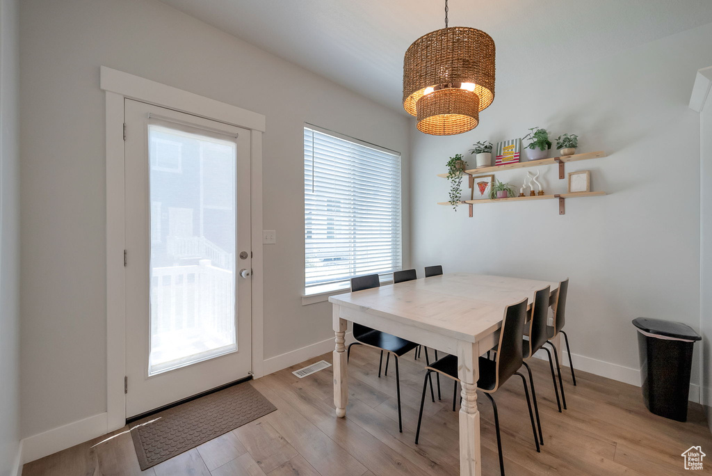 Dining area with a chandelier and light wood-style flooring