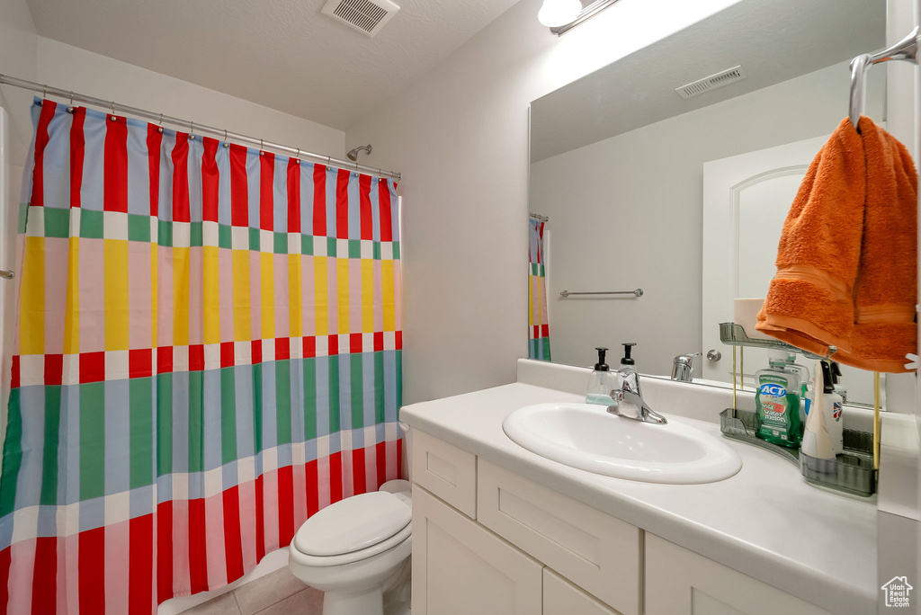 Bathroom featuring vanity, tile patterned floors, and a shower with shower curtain