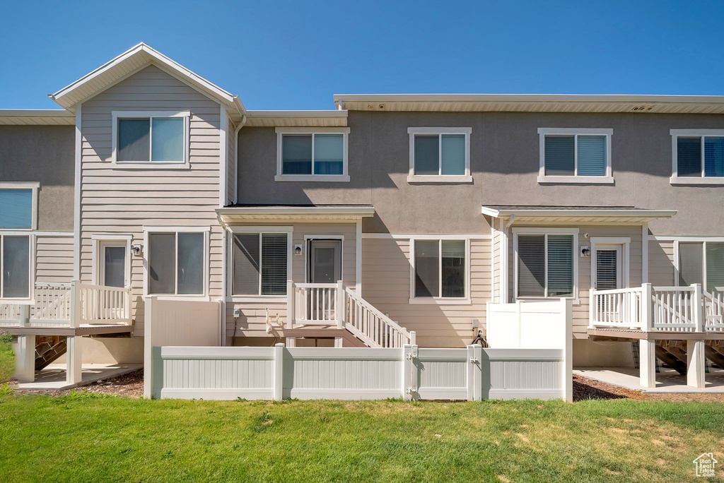 Rear view of property with a wooden deck and stucco siding