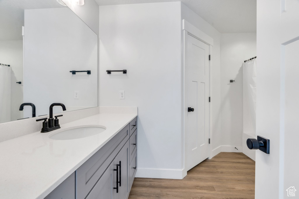 Full bathroom with vanity and wood finished floors