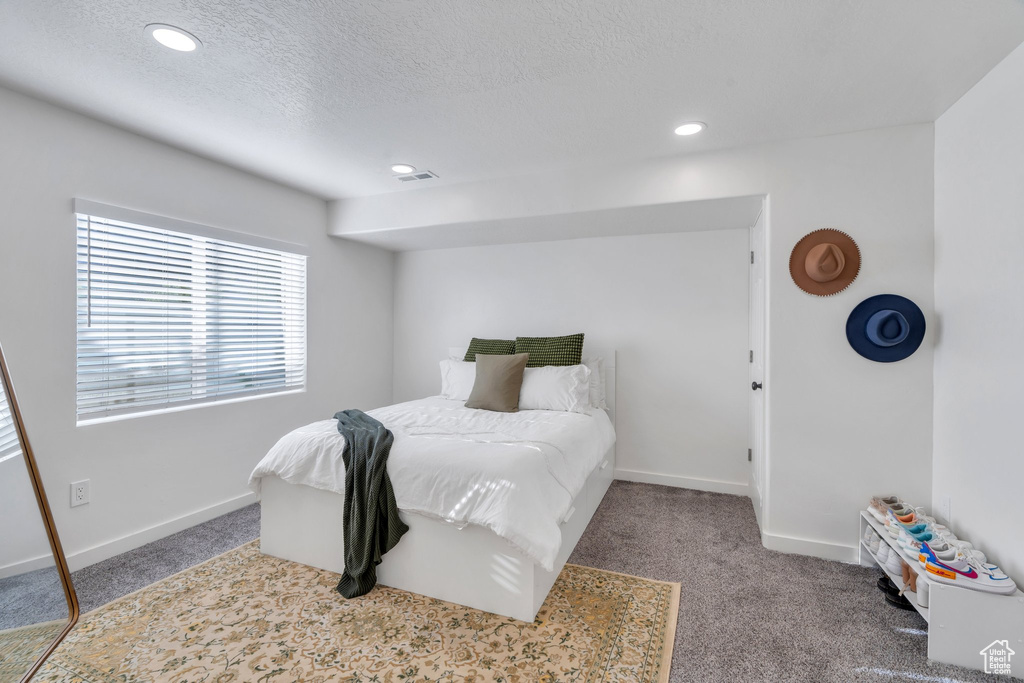 Bedroom with carpet, recessed lighting, and a textured ceiling