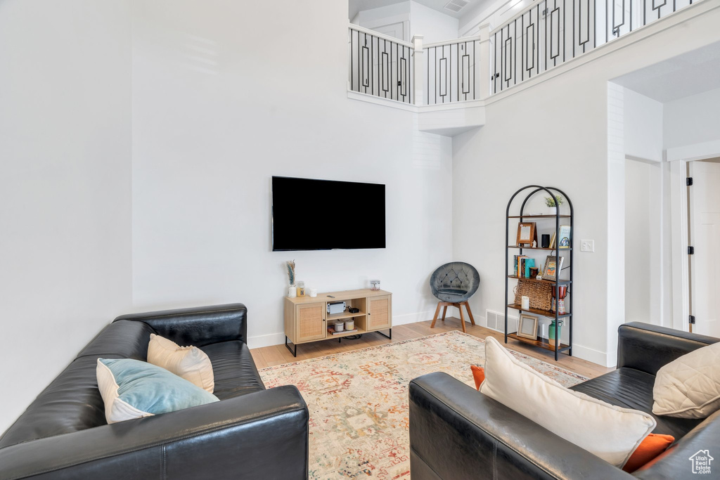 Living area featuring wood finished floors and a high ceiling