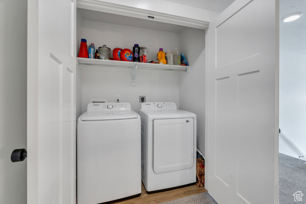 Laundry room featuring washer and dryer and light wood-style floors