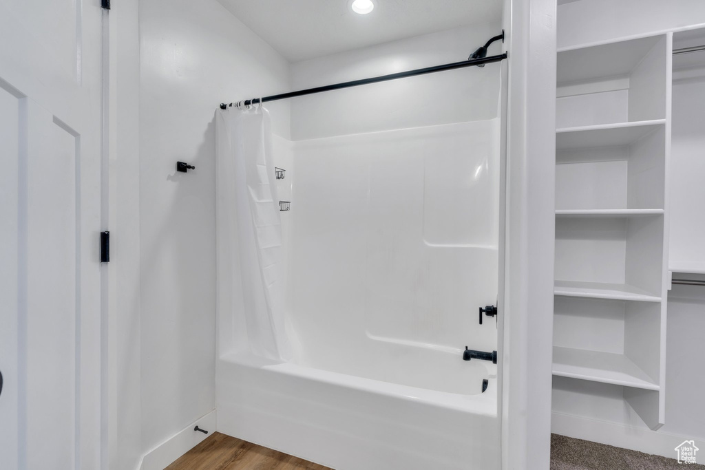 Full bath with shower / bath combo and baseboards