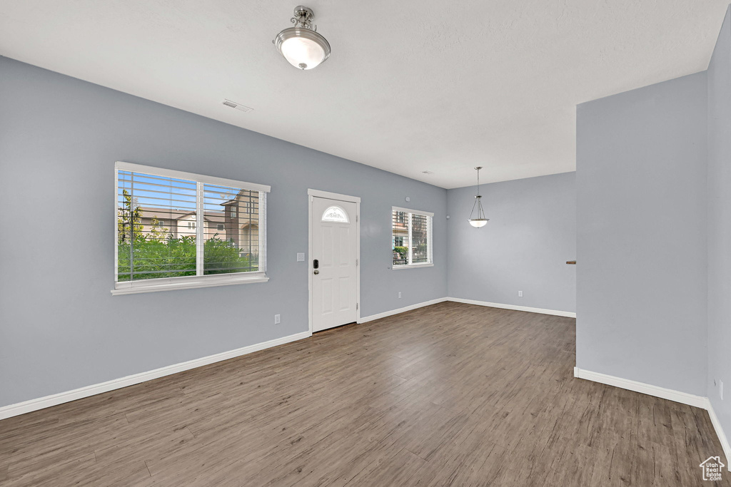 Foyer with baseboards and wood finished floors