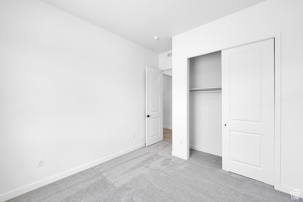 Unfurnished bedroom featuring carpet and a closet
