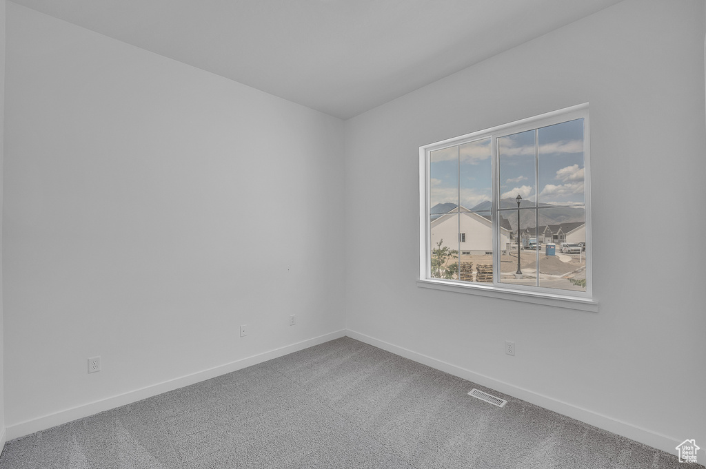 Empty room featuring baseboards and carpet floors