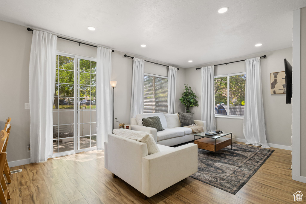 Living area featuring healthy amount of natural light, wood finished floors, and recessed lighting