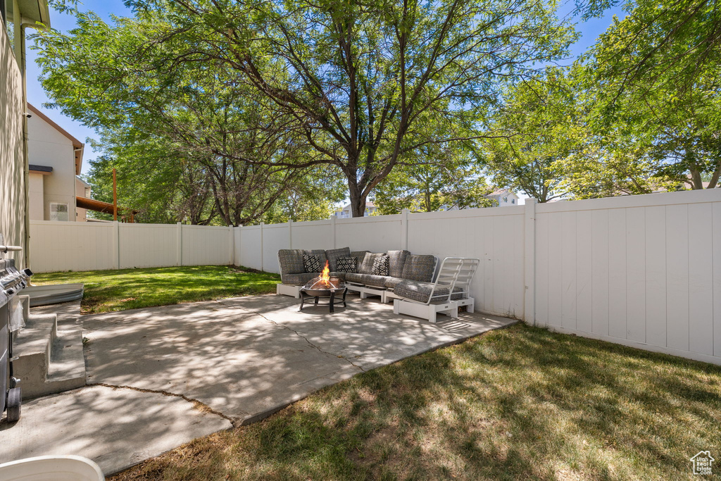 Fenced backyard featuring an outdoor living space with a fire pit and a patio area