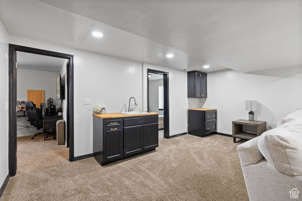 Bedroom featuring light carpet, recessed lighting, and an office area