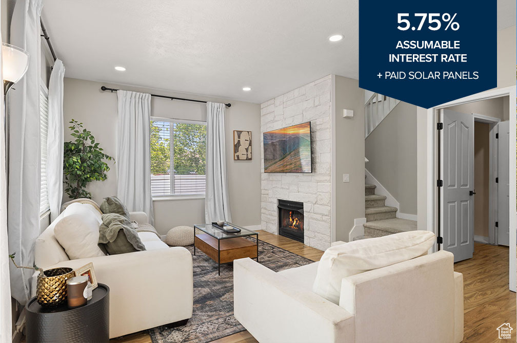 Living area with wood finished floors, stairs, a fireplace, and recessed lighting