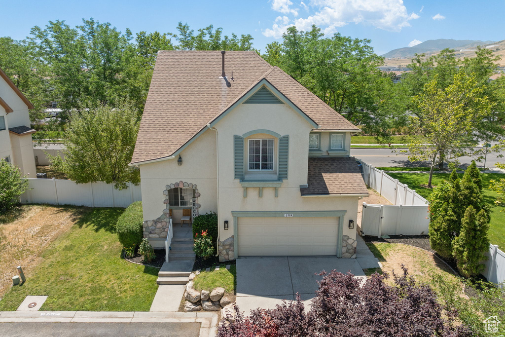 View of front of property with stone siding, stucco siding, a shingled roof, an attached garage, and driveway