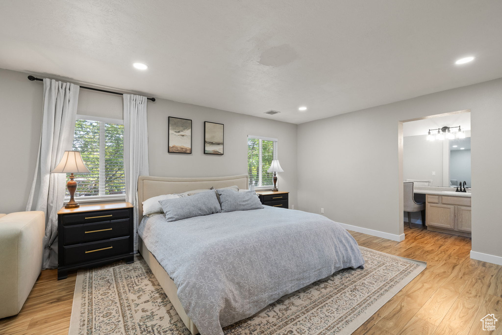 Bedroom featuring light wood-style floors, recessed lighting, and ensuite bathroom