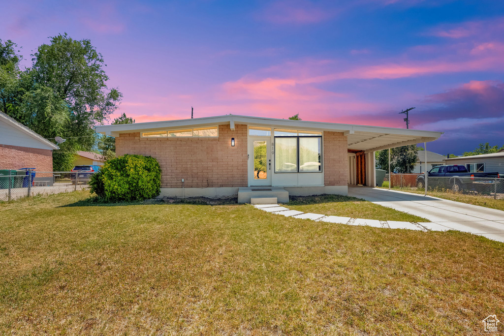 View of front of house with a carport, brick siding, driveway, and entry steps