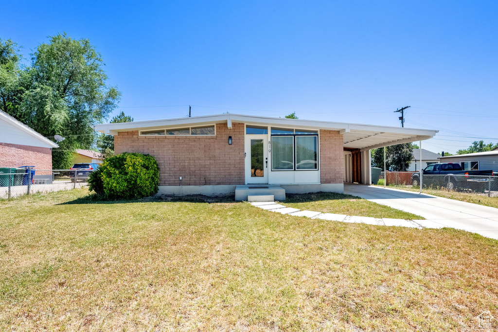 Mid-century inspired home with a carport, driveway, entry steps, and brick siding
