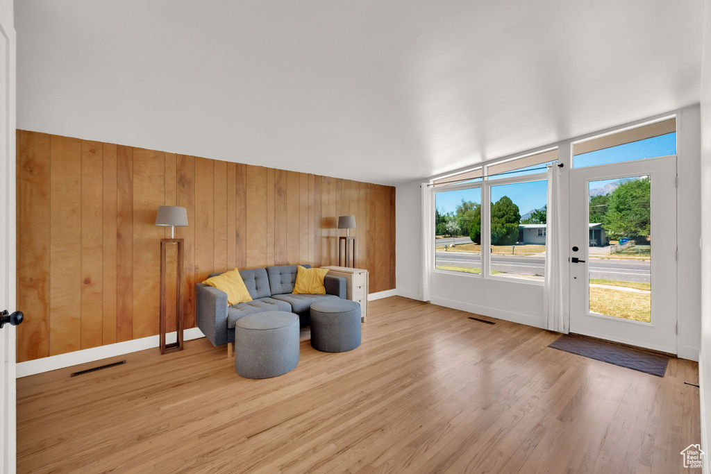 Living area featuring light wood-style floors and wood walls