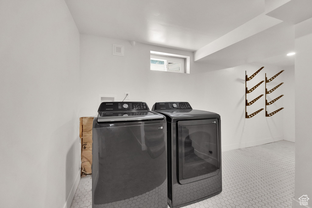Laundry room featuring washing machine and clothes dryer and tile patterned flooring