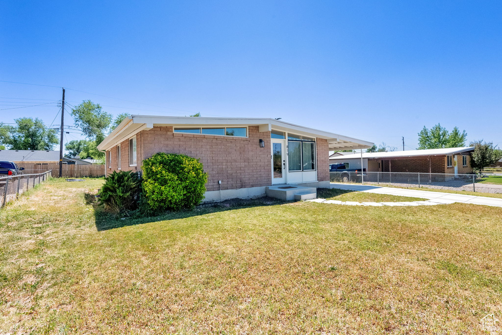 Back of property featuring brick siding and a carport