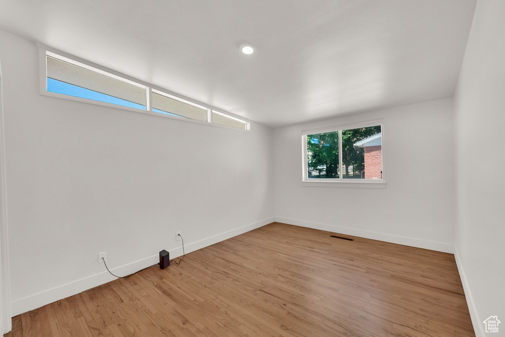 Empty room with wood finished floors, recessed lighting, and lofted ceiling