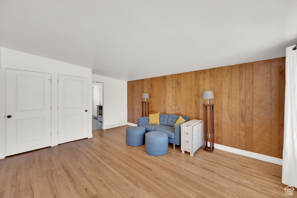Sitting room featuring light wood-style floors and wooden walls