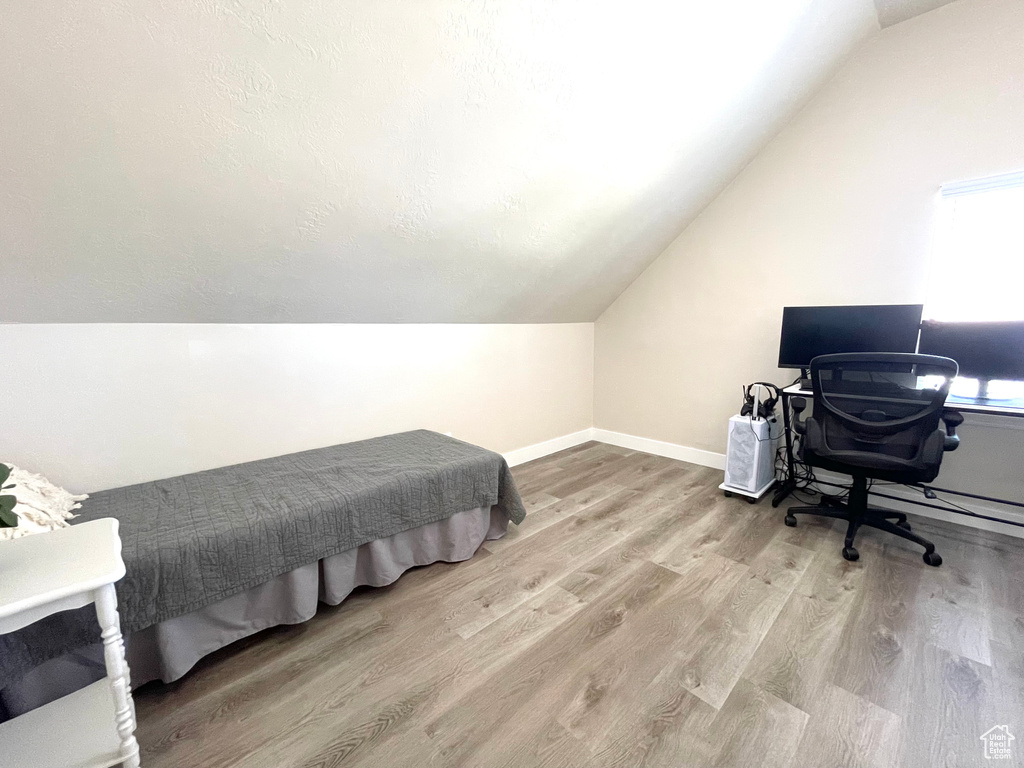 Bedroom with vaulted ceiling and wood finished floors