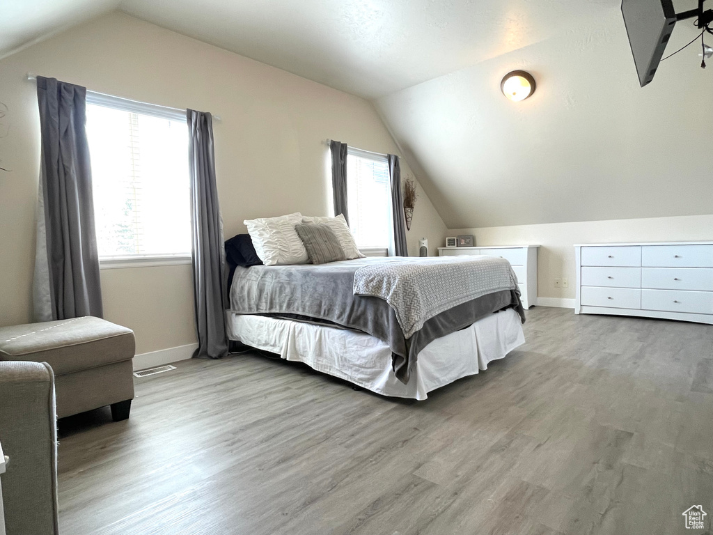 Bedroom featuring lofted ceiling and wood finished floors