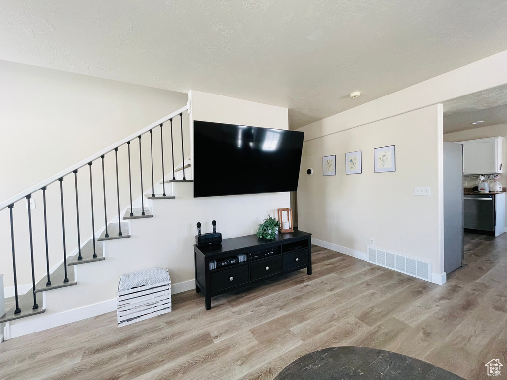 Living area with light wood finished floors and stairway