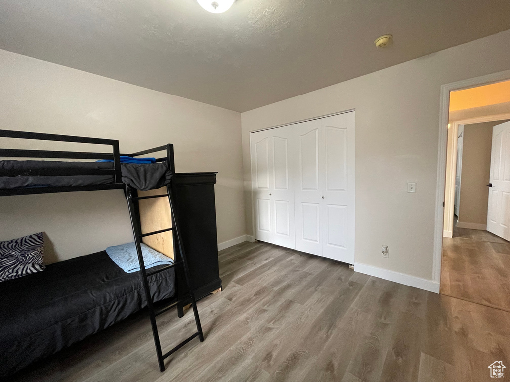 Bedroom featuring wood finished floors and a closet