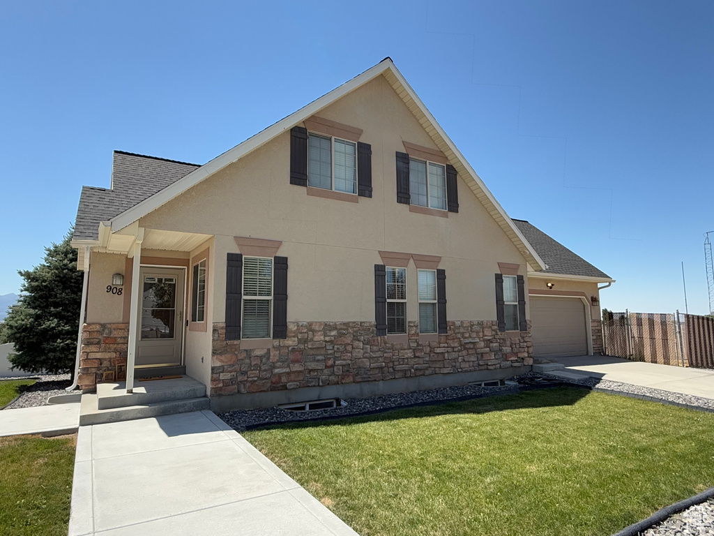 View of front of property featuring stone siding, a shingled roof, concrete driveway, and an attached garage