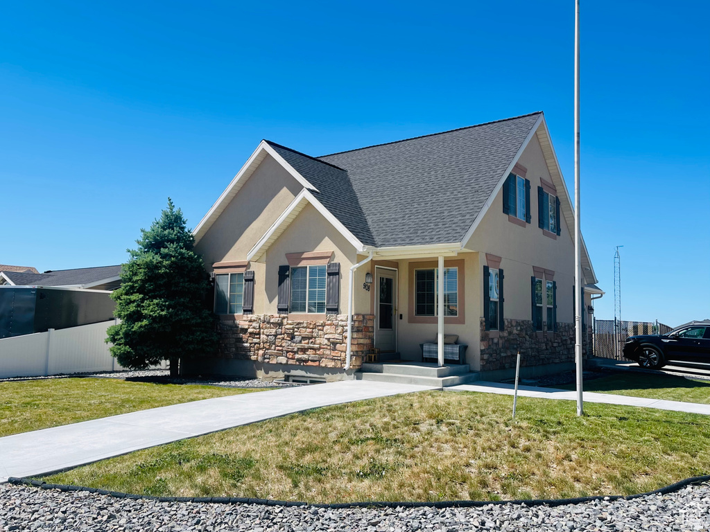 View of front of home featuring stucco siding, stone siding, and a shingled roof