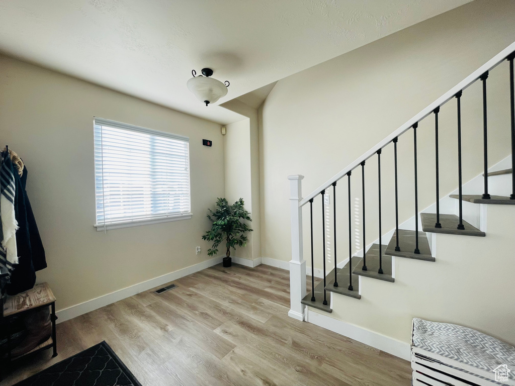 Stairs with wood finished floors and baseboards