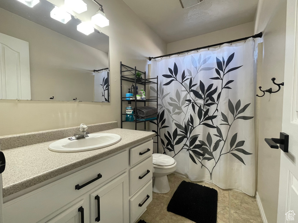 Bathroom with vanity, curtained shower, and tile patterned floors
