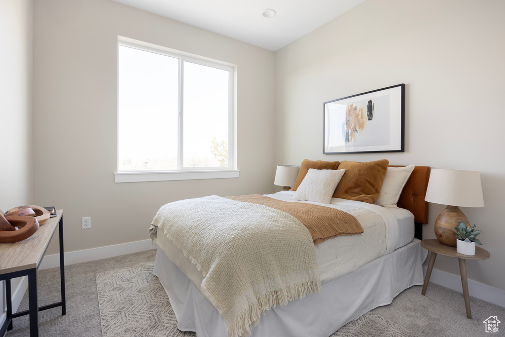 Bedroom featuring light colored carpet and baseboards