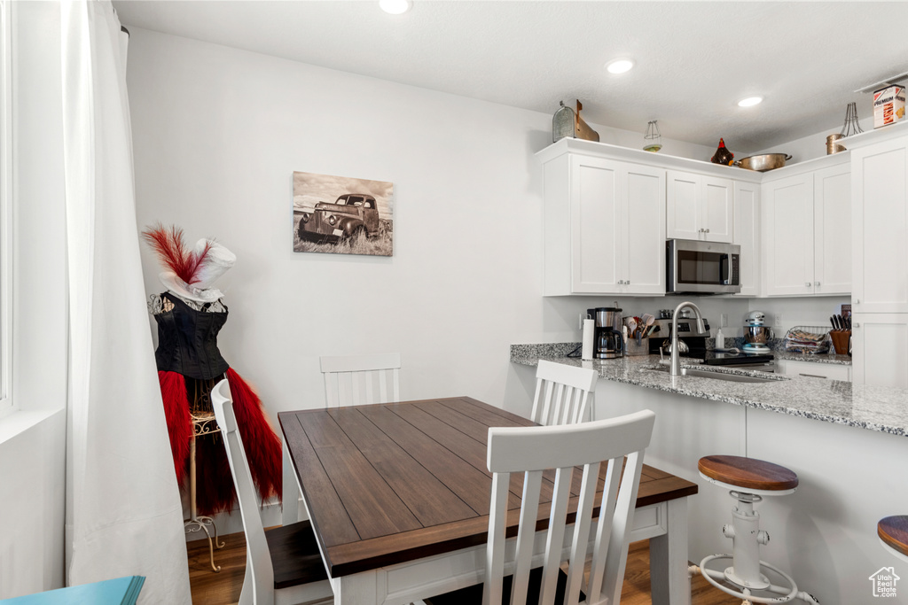 Dining area with recessed lighting and wood finished floors