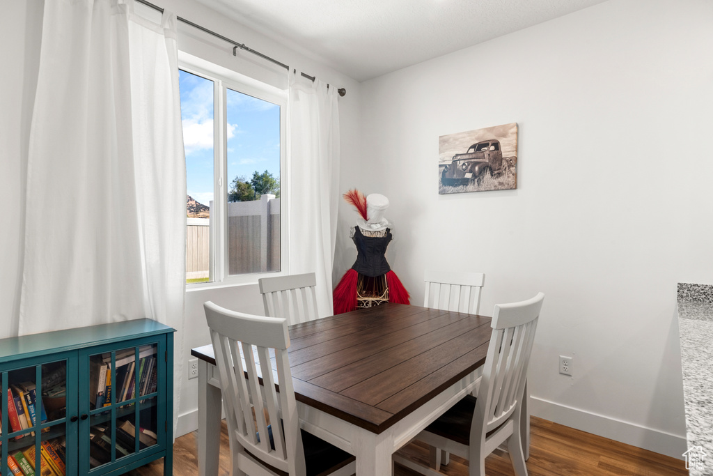 Dining space with healthy amount of natural light and wood finished floors