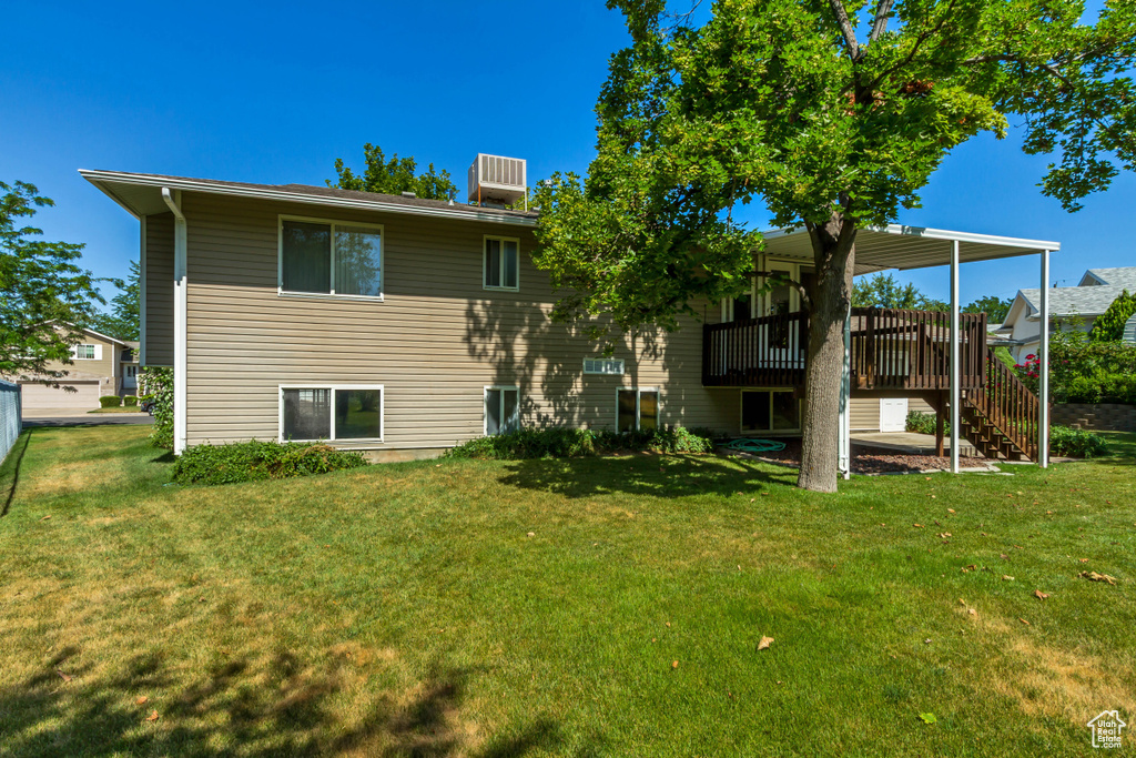 Back of house featuring a wooden deck, a yard, and stairway