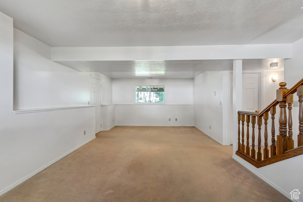 Spare room featuring light carpet and stairway