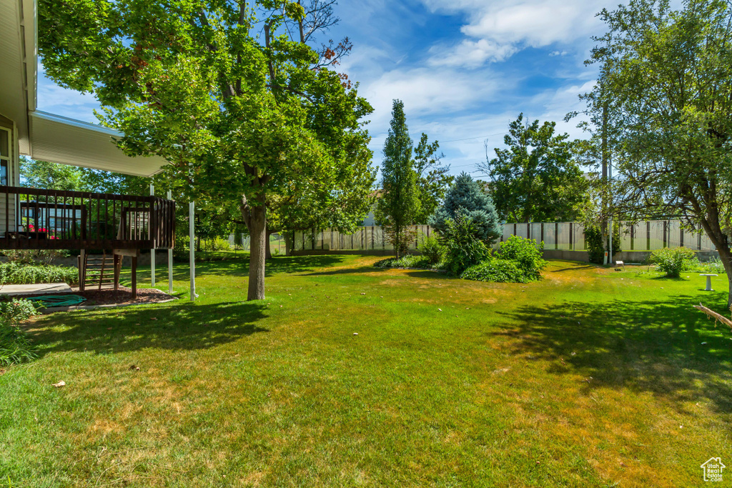 View of yard with a wooden deck and stairway