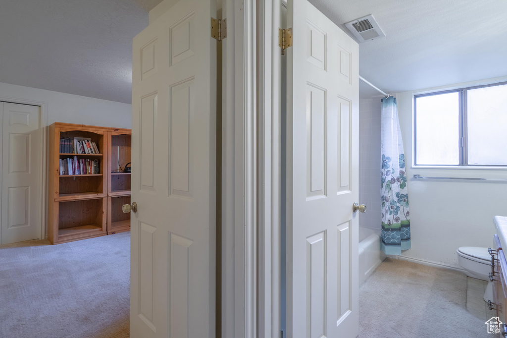 Full bathroom featuring toilet and shower / bath combo with shower curtain