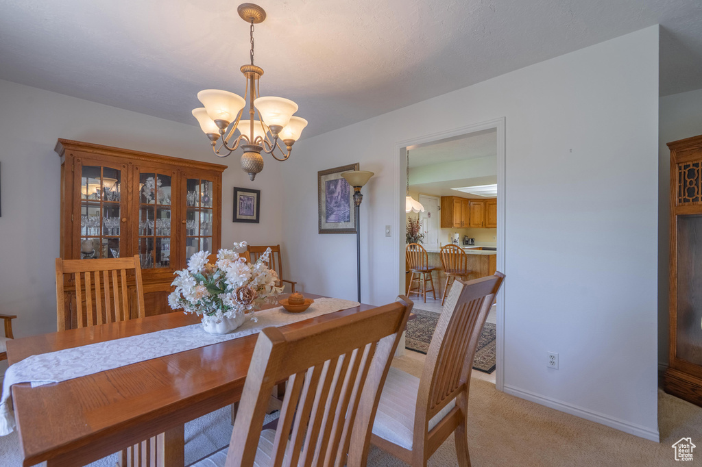 Dining room with a chandelier and light carpet