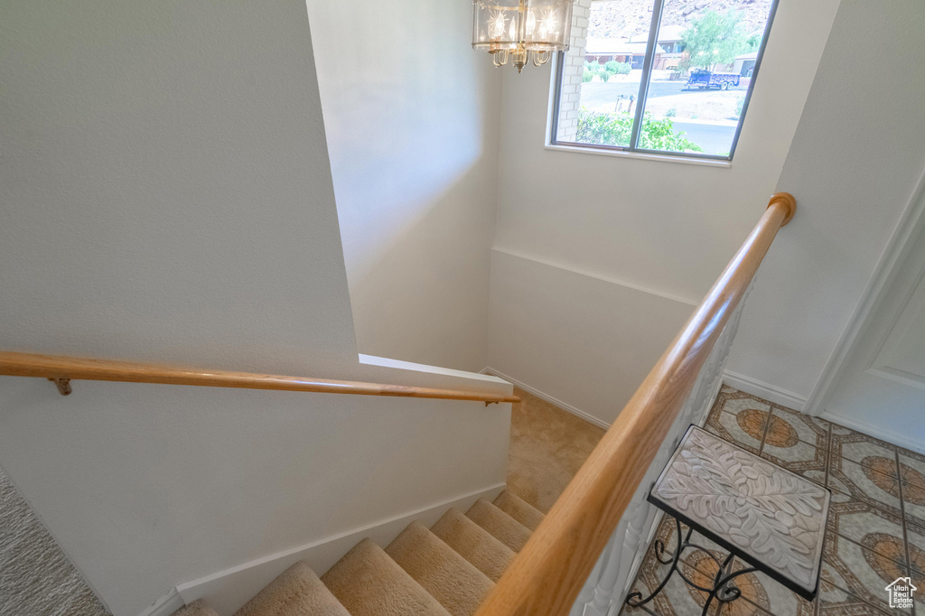 Staircase with a chandelier and baseboards