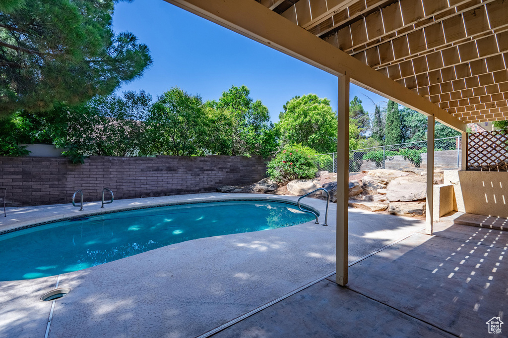 View of swimming pool featuring a fenced backyard and a patio
