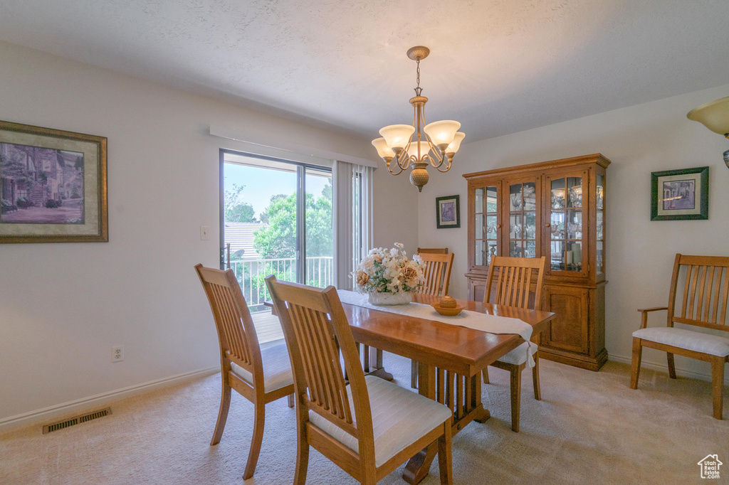 Dining room with a chandelier and light colored carpet